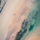 Une belle photographie de sable rosé mêlé aux eaux turquoise de la plage de Sables-d'Or-Les-Pins en Bretagne à l'ouest de la France. (La plage rosée de Sables-d'Or-Les-Pins en Bretagne)